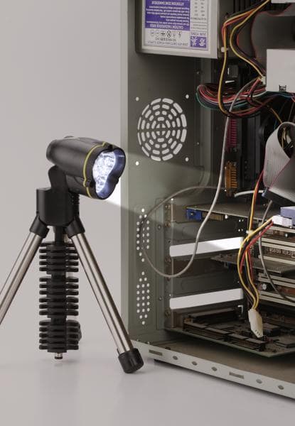 STANLEY 95-112 tripod LED flashlight illuminating open computer case, side angle, visible cables and components.