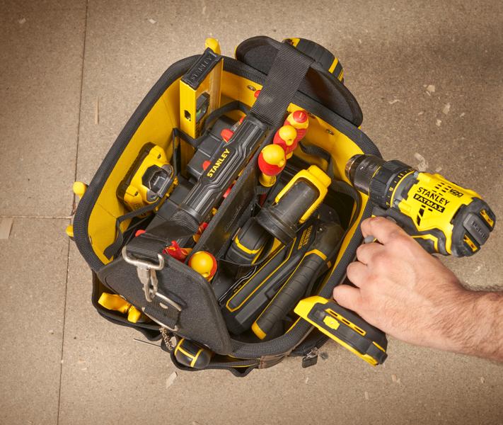 STANLEY 1-93-952 photographie d’un sac à outils ouvert avec outils jaunes et une perceuse sans fil, vue de dessus.