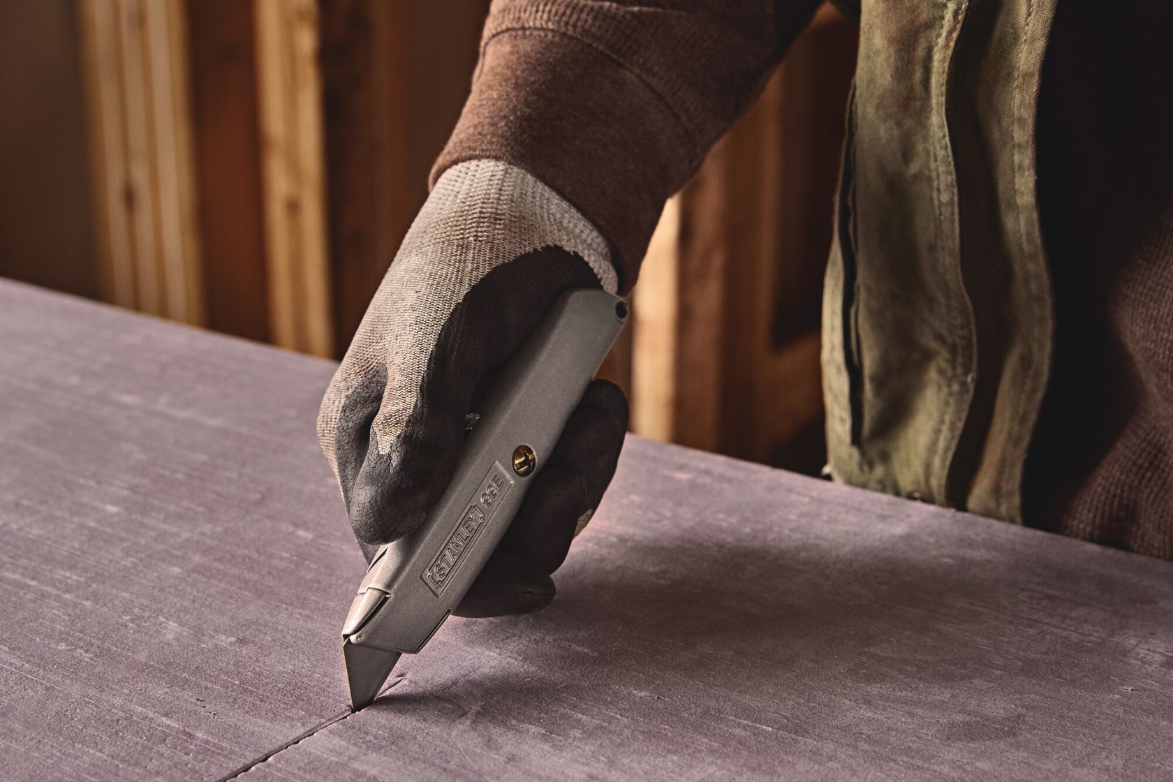 Closeup of 6 Inch Classic 99 retractable utility knife cutting hard surface.