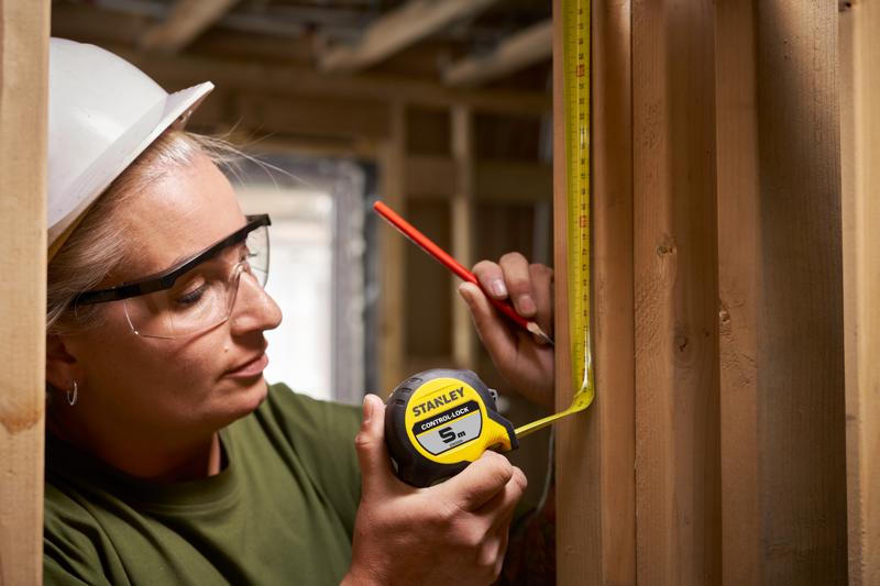STANLEY® CONTROL-LOCK™ 5M (25mm wide) Tape Measure being used by worker to measure timber frame