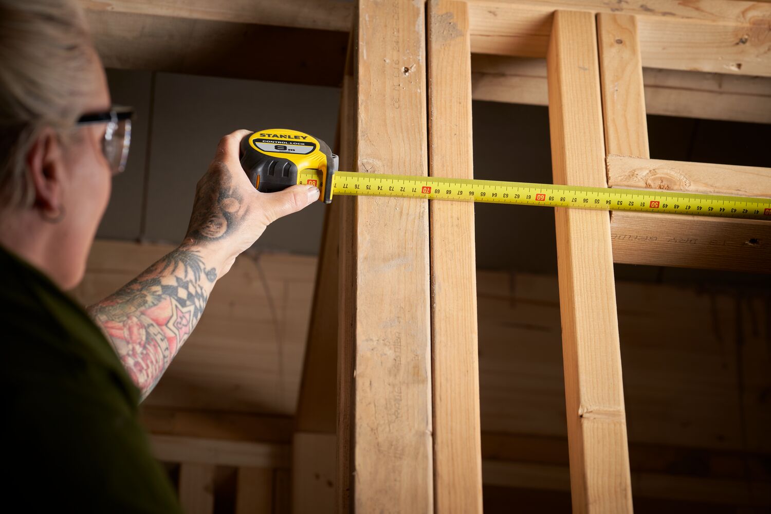 STANLEY® CONTROL-LOCK™ 8M (25mm wide) Tape Measure being used by worker on wooden frame